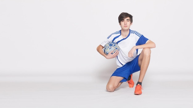 Excited sports fan holding football and gesturing isolated on white background