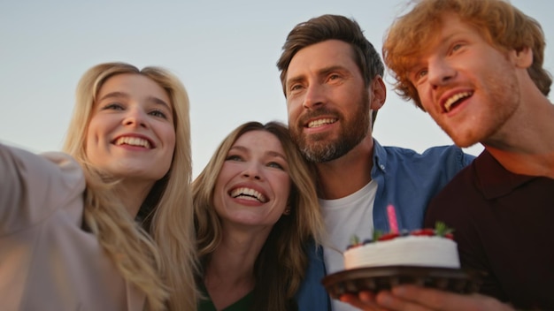 Excited woman celebrating birthday with cheerful friends outdoors close up