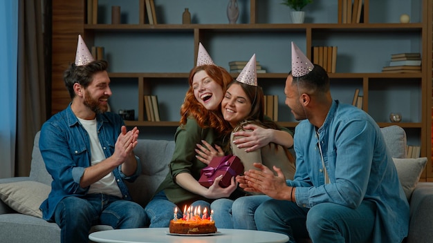 Excited woman receive gift present from friends diverse multiracial colleagues congratulate wish