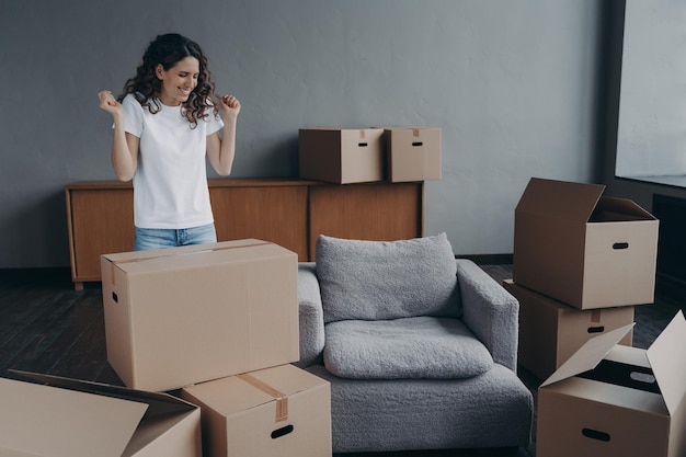 Excited young woman is packing things Spanish girl moves to new house Real estate purchase