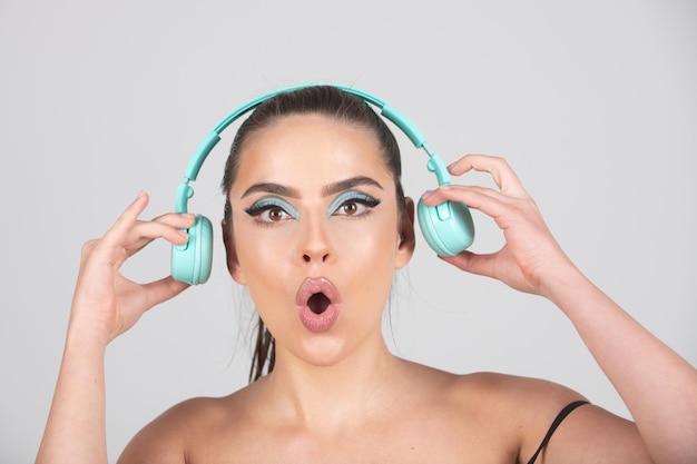 Excited young woman listen music with headphones dancing girl listening to music using wireless earp