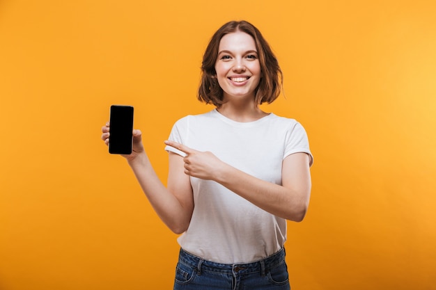 Excited young woman showing display of by mobile phone.