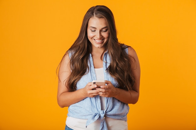 Excited young woman, using mobile phone, celebrating