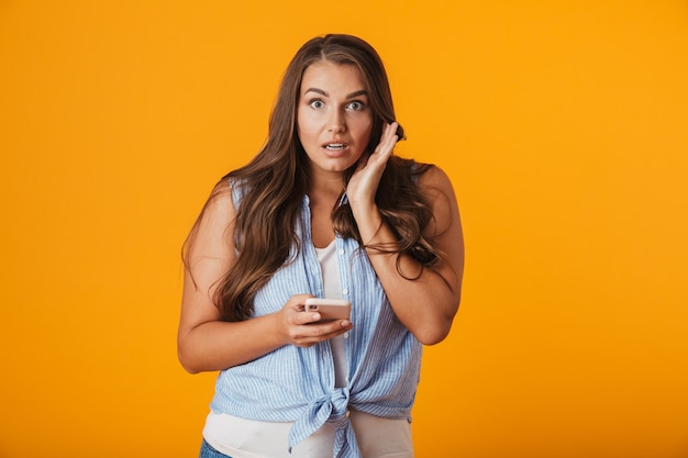 Excited young woman, using mobile phone, celebrating