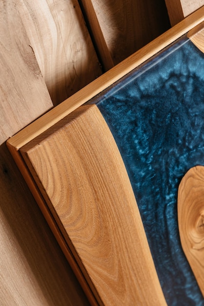 Exclusive handmade table of solid wood and epoxy resin on the background of wood boards