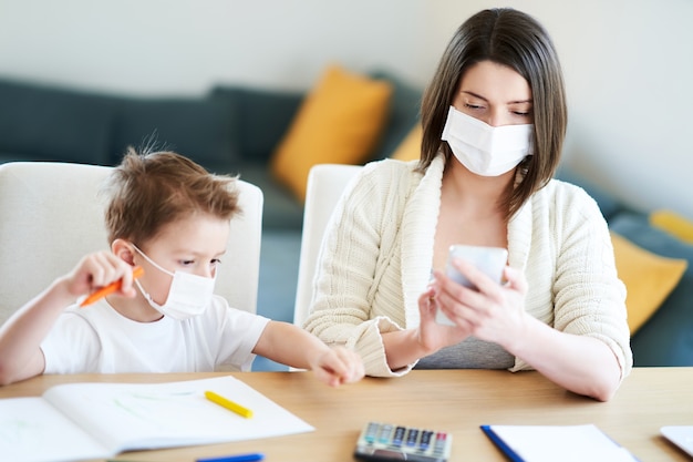 exhausted mother trying to work at home and taking care of her son during coronavirus pandemic