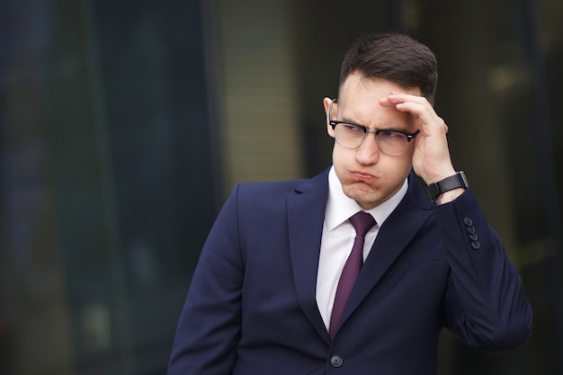 exhausted overworked businessman in formal suit outdoors