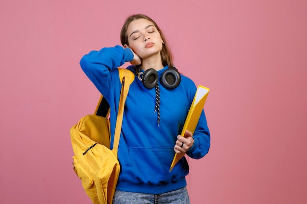 Exhausted schoolgirl standing with closed eyes