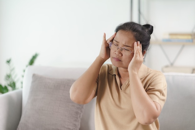 Exhausted tired depressed stressed thoughtful mature senior woman suffering from headaches, Brain diseases, mental problems, Alzheimer Concept.