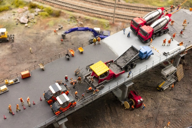 The exhibition of Grand maket Russia.Workers and service vehicles are building a new bridge, a fragment of a selfcontained large layout in Russia.