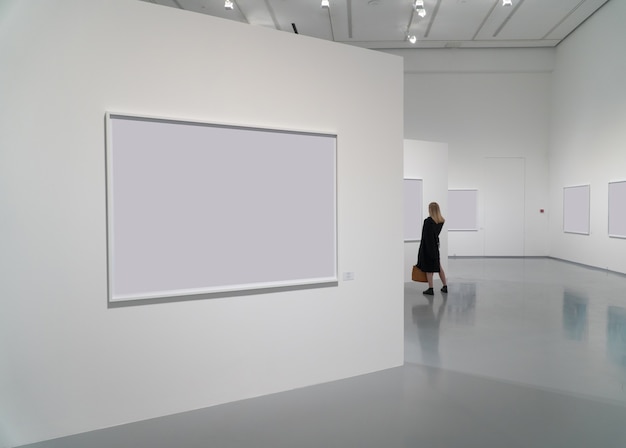 Exhibition room of the gallery with blank pictures and people