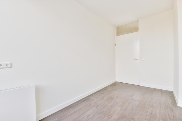 Exit from a small cozy empty room with a parquet floor and a white door