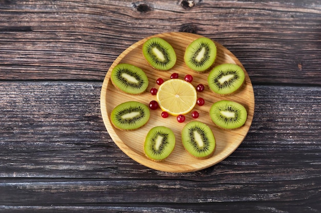 Exotic fruits are laid out in a pattern on a wooden plate.