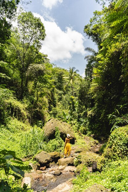 Exotic greenery. Attractive girl spending her vacation active while walking in jungles and filling her soul with nature