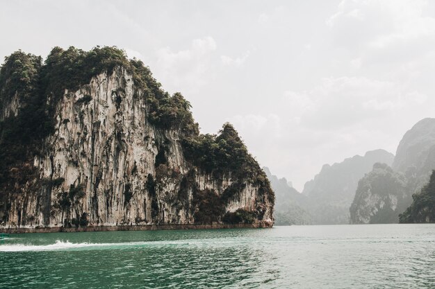 Exotic and tropical dark green islands with rocks and green lake at Cheow Lan Lake, Khao Phang, Ban Ta Khun District