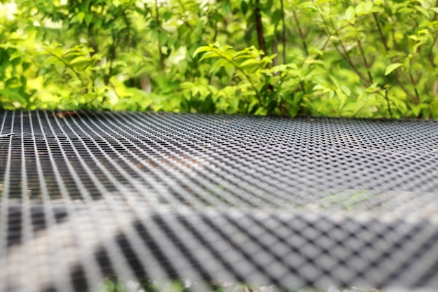 Expanded metal floor in garden.Very shallow depth of field composition.