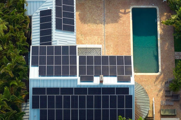 Expensive american residential house with rooftop covered with solar photovoltaic panels for producing of clean ecological electrical energy in suburban rural area Concept of autonomous home