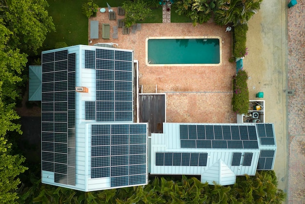 Expensive american residential house with rooftop covered with solar photovoltaic panels for producing of clean ecological electrical energy in suburban rural area Concept of autonomous home