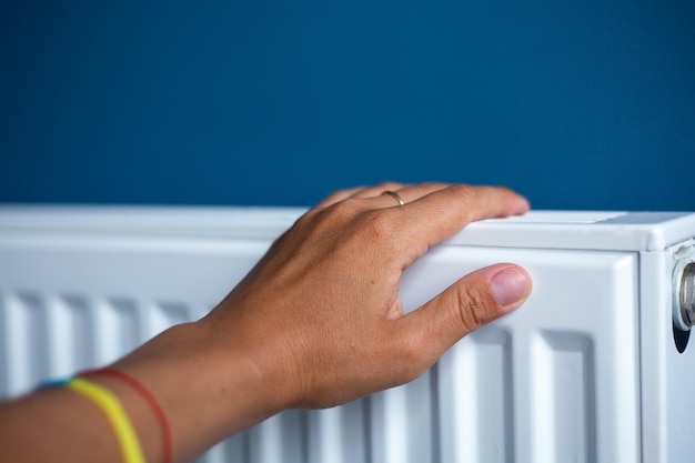 Expensive heating season in Ukraine Woman's hand on the radiator