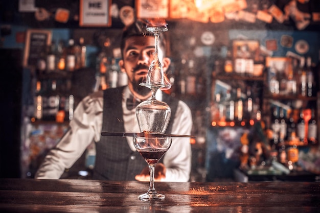 Experienced barman places the finishing touches on a drink