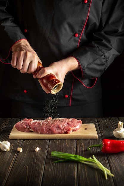 Experienced chef prepares the veal meat and adds pepper or chili