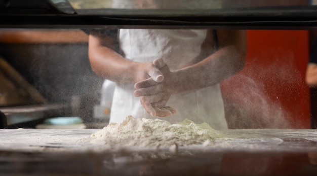 Photo experienced chef professional chef prepares the dough with flour to make pizza or pasta italian food