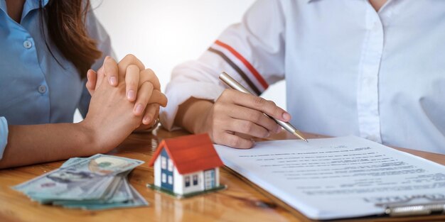 Photo experienced real estate agent showing house model to client and ready to sign contract