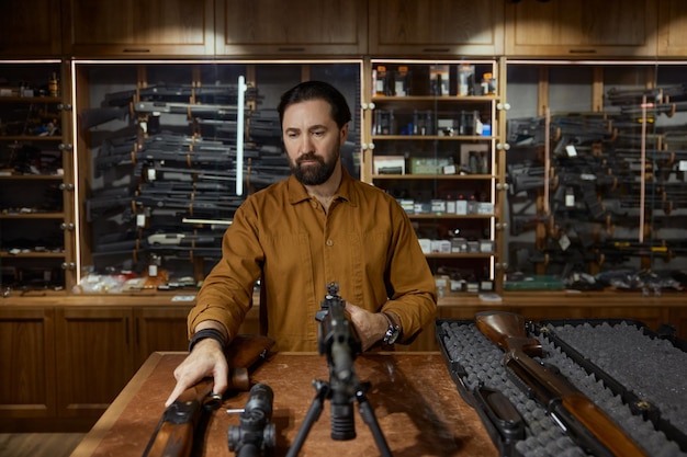 Photo experienced salesman showing new gun machine for clients