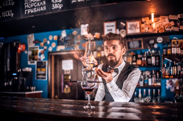 Experienced tapster makes a show creating a cocktail at the nightclub