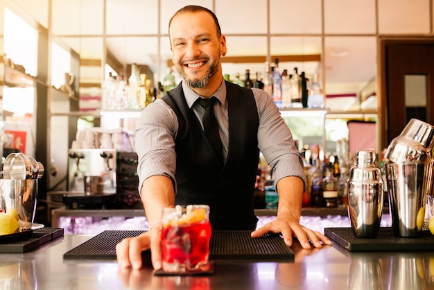 Expert barman is making cocktail at night club