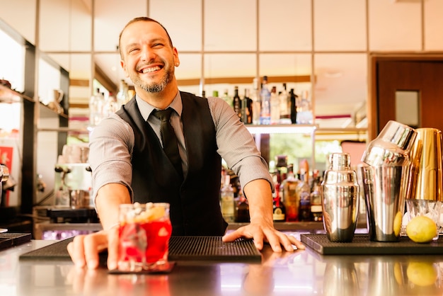 Expert barman is making cocktail at night club