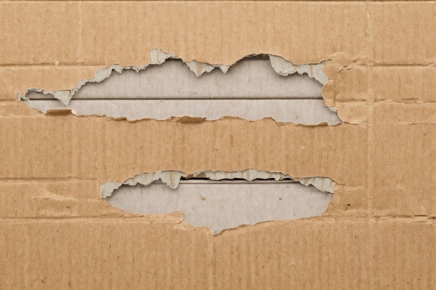 Photo exploring texture and depth the aesthetic impact of torn cardboard backgrounds