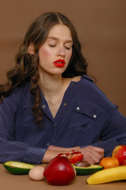 Expressive beautiful lady posing with fruits