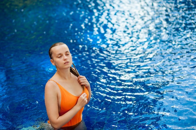 Expressive beautiful woman posing in the swimming pool