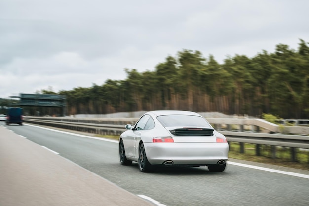 Exquisite Speed and Style on the Highway Modern European Sportcar Silver German roadster vehicle on the highway Silver sport coupe The expensive sports car on public roads Autobahn speeding