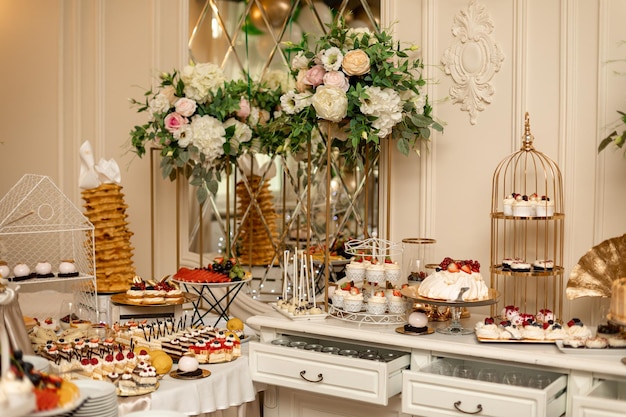 Exquisitely decorated sweet buffet at wedding banquet. Varied buffet. Festive event. Organization of banquets and weddings. Sweet desserts. Exquisite wedding treats. Wedding decoration.