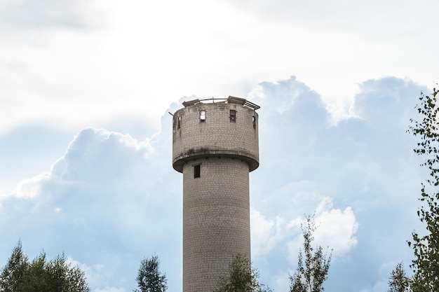 Exterior of abandoned water tower with collapsed roof and broken windows