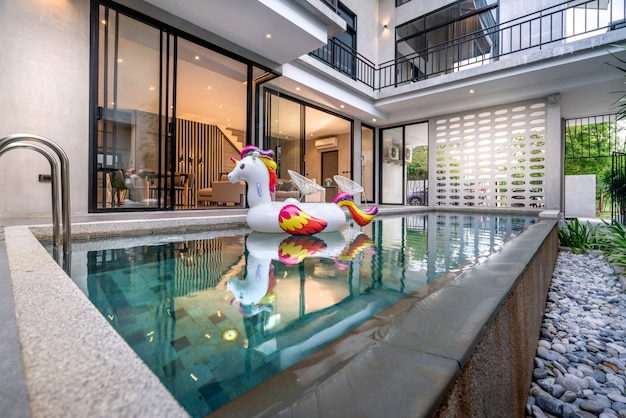 Exterior home with swimming pool and floating unicorn in the house