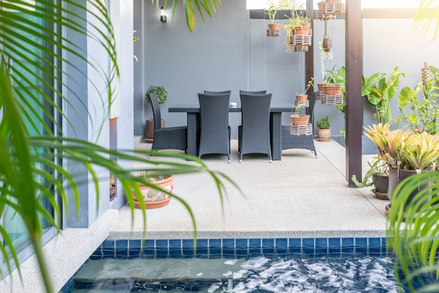  Exterior  and interior design showing tropical pool villa with green garden, with sun bed and blue sky 