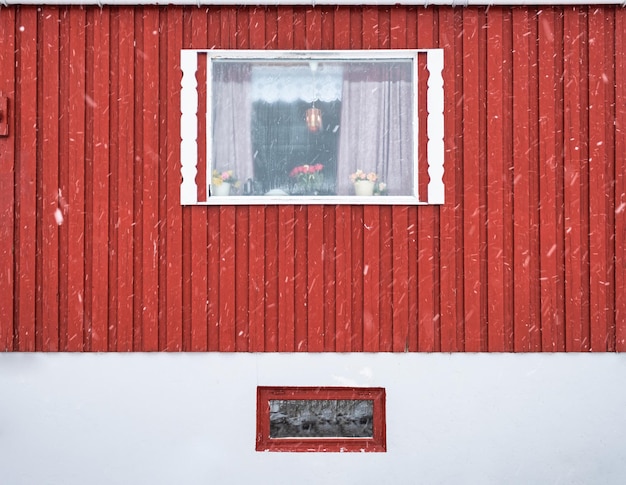 Exterior of red hardwood wall and window frame of fishing nordic house on winter season in Lofoten Islands