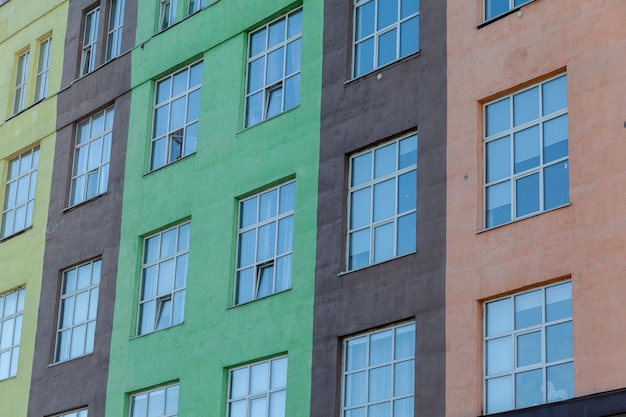 The exterior of a tall building with windows. A newly built building for offices and housing.