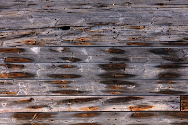 Exterior wooden wall with rusty nails