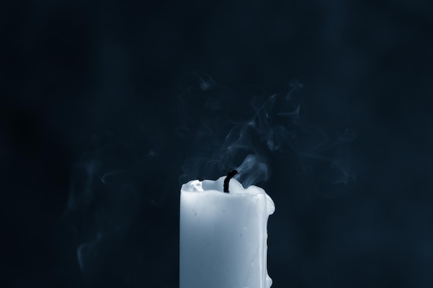 Extinct blue candle with spectacular, abstract blue smoke on a dark blue background, close-up, frozen smoke. Classic blue, trend 2020