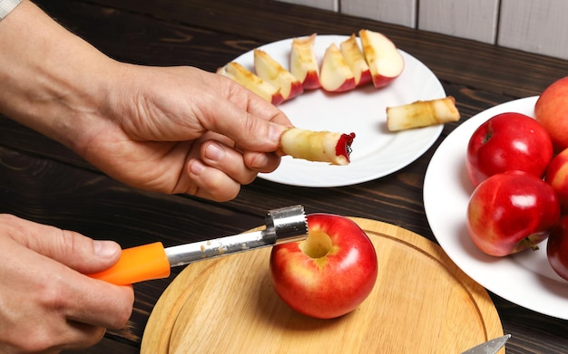 extracted core from red juicy apple in hand and special knife for cutting core from fruit