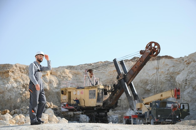 Photo extraction of stone male worker next to stone quarry engineer at construction site