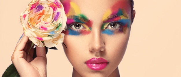 Extravagant multi colored makeup on the appealing face Woman face shaded in a different colors