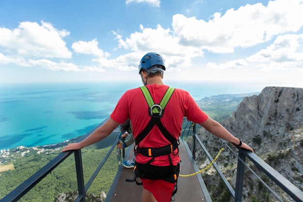 An extreme athlete walks across the bridge to the cliff Jumping rope