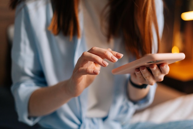 Extreme close-up of woman hands texting message on mobile cellphone for communication and chatting on social online. Closeup view female hands hold mobile phone modern gadget typing sms to friend.