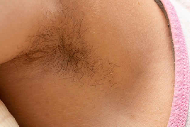 An extreme closeup view on the armpit of a thirty year old male wearing vest top healthy woman