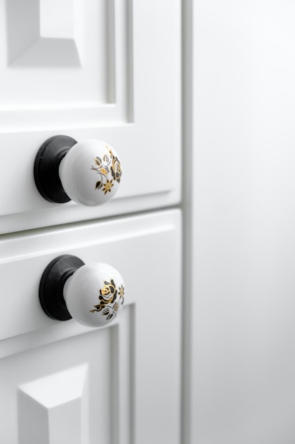 Extremely closeup detail of vintage white cabinet original ceramic handles selective focus copy space